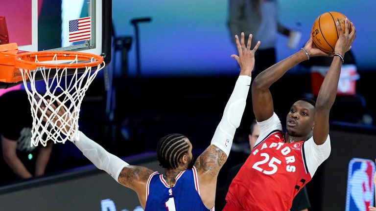 Chris Boucher #25 of the Toronto Raptors goes up for a shot against Mike Scott #1 of the Philadelphia 76ers during the second half at The Field House at ESPN Wide World Of Sports Complex on August 12, 2020 in Lake Buena Vista, Florida. 