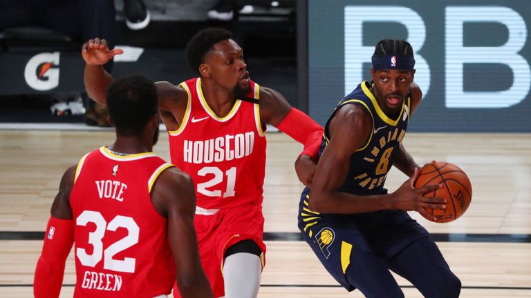 Justin Holiday #8 of the Indiana Pacers drives to the basket against Michael Frazier #21 and Jeff Green #32 of the Houston Rockets in the fourth quarter at AdventHealth Arena at ESPN Wide World Of Sports Complex on August 12, 2020 in Lake Buena Vista, Florida. 