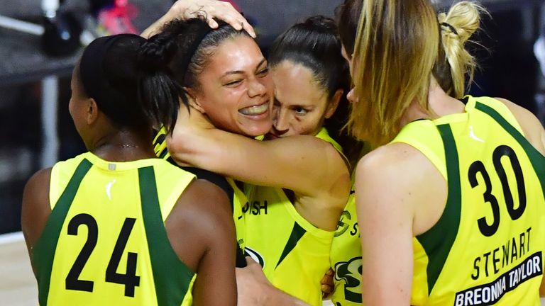 Alysha Clark is mobbed by her team-mates after hitting the game-winner for the Seattle Storm against the Minnesota Lynx
