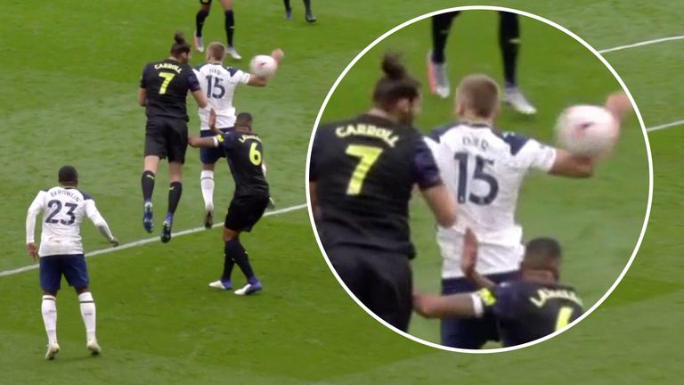 Andy Carroll heads the ball against the arm of Eric Dier