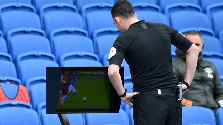 Referee Chris Kavanagh checks the pitchside monitor before deciding to not award Brighton a penalty