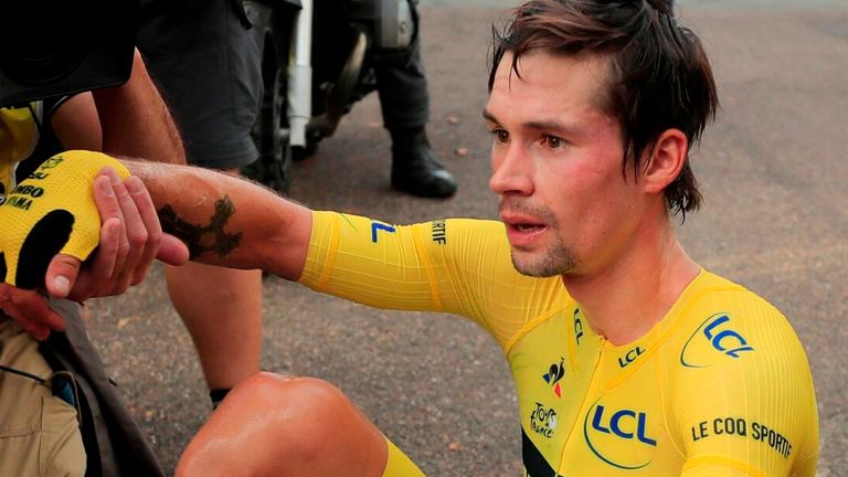 Team Jumbo rider Slovenia's Primoz Roglic wearing the overall leader's yellow jersey (down) after crossing the finish line at the end of the 20th stage of the 107th edition of the Tour de France cycling race, a time trial of 36 km between Lure and La Planche des Belles Filles, on September 19, 2020.