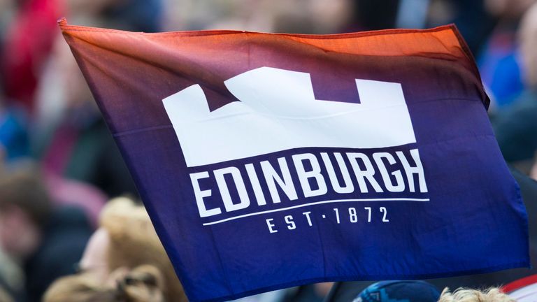 An Edinburgh fan waves a flag in the crowd. 