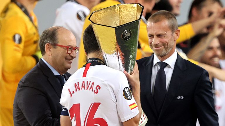 UEFA President Aleksander Ceferin (R) hands the Europa League Trophy to Sevilla captain Jesus Navas