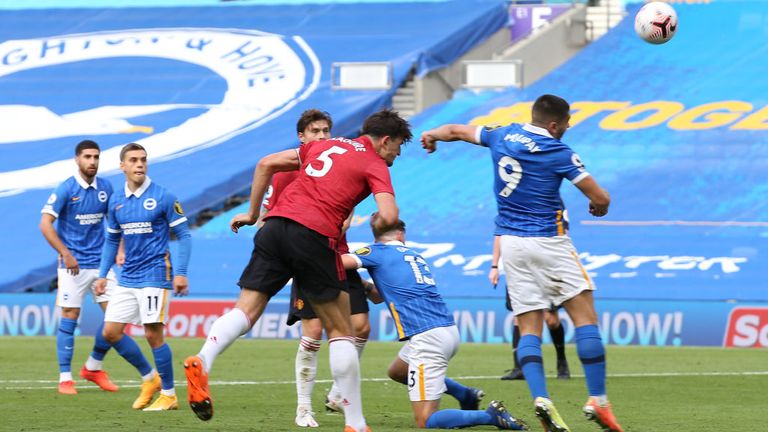 Harry Maguire heads against the outstretched arm of Neal Maupay