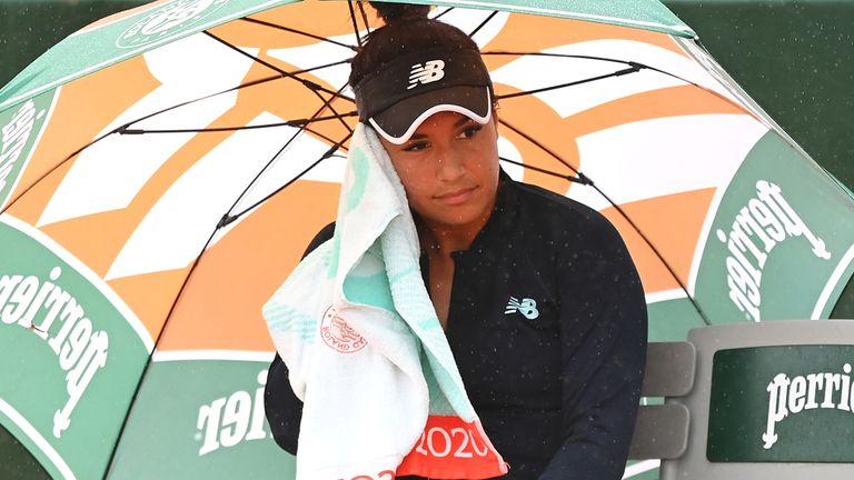 Heather Watson of Great Britain sits down in between games as she hold an umbrella as rain falls during her Women's Singles first round match against Fiona Ferro of France on day three of the 2020 French Open at Roland Garros on September 29, 2020 in Paris, France