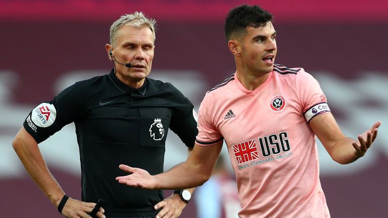 John Egan reacts after referee Graham Scott shows him a red card for denying Ollie Watkins a goalscoring opportunity