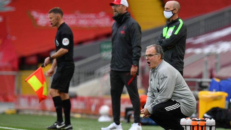 Bielsa crouches down on the touchline at Anfield on the opening day