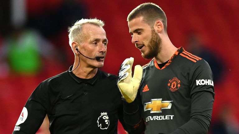 Referee Martin Atkinson speaks with with David De Gea after awarding a penalty to Crystal Palace