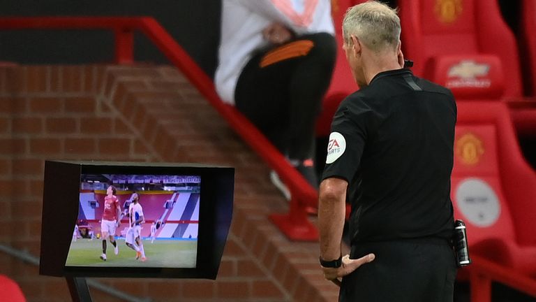Referee Martin Atkinson checks the pitchside VAR before awarding a penalty to Crystal Palace
