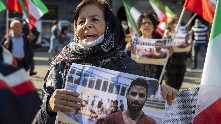 A woman holds a portrait of Iranian wrestler Navid Afkari during a demonstration on the Dam Square in Amsterdam, the Netherlands