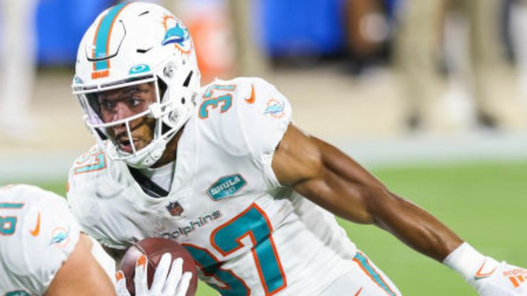 Myles Gaskin #37 of the Miami Dolphins runs for yardage against C.J. Henderson #23 of the Jacksonville Jaguars during a game at TIAA Bank Field on September 24, 2020 in Jacksonville, Florida. 