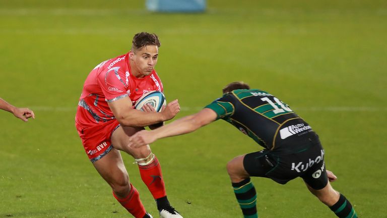 Rohan Janse van Rensburg looks to get through the tackle of  Dan Biggar