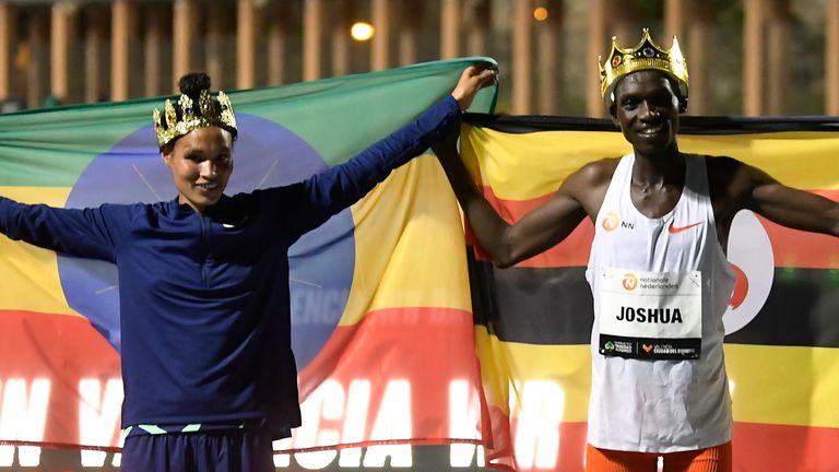 Letesenbet Gidey, left, and Joshua Cheptegei pose after breaking the 5,000m and 10,000m track world records, respectively