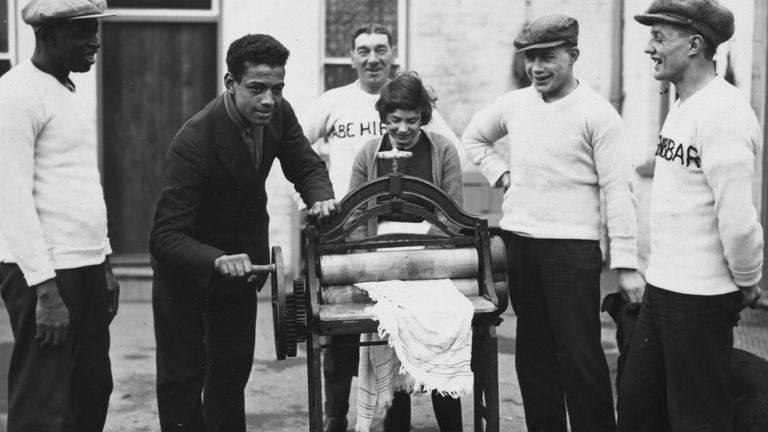 31st December 1926: Len Johnson British light-heavyweight boxing champion, helps with the mangling, his father is on the left. (Photo by Brooke/Topical Press Agency/Getty Images)