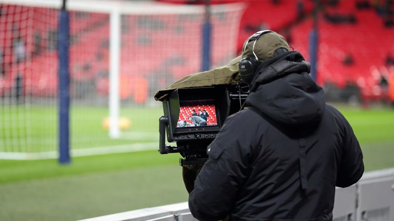 A TV camera operator filming a Premier League match
