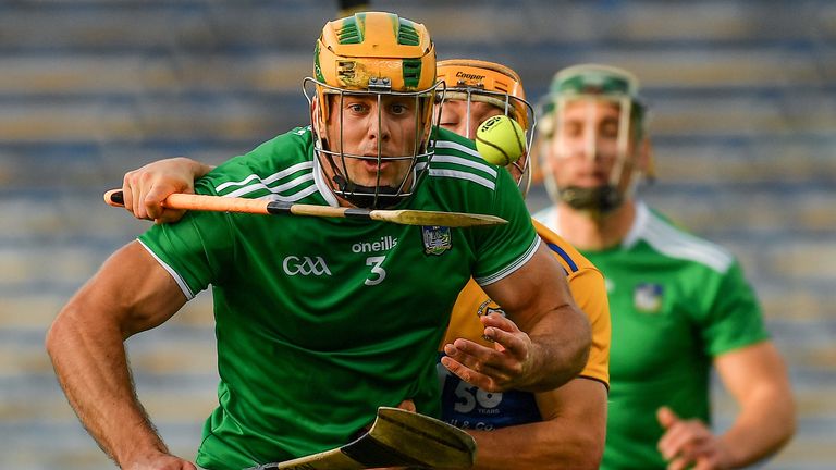 David Reidy of Clare taps the sliotar away from Dan Morrissey of Limerick