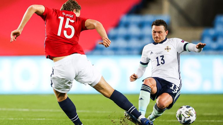 Corry Evans slides in to dispossess Sander Berge in the Nations League clash