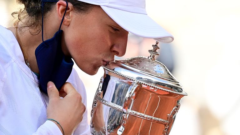 Poland's Iga Swiatek kisses and celebrates with the Suzanne Lenglen trophy during the podium ceremony after winning the women's singles final tennis match against Sofia Kenin of the US, at the Philippe Chatrier court, on Day 14 of The Roland Garros 2020 French Open tennis tournament in Paris on October 10, 2020.