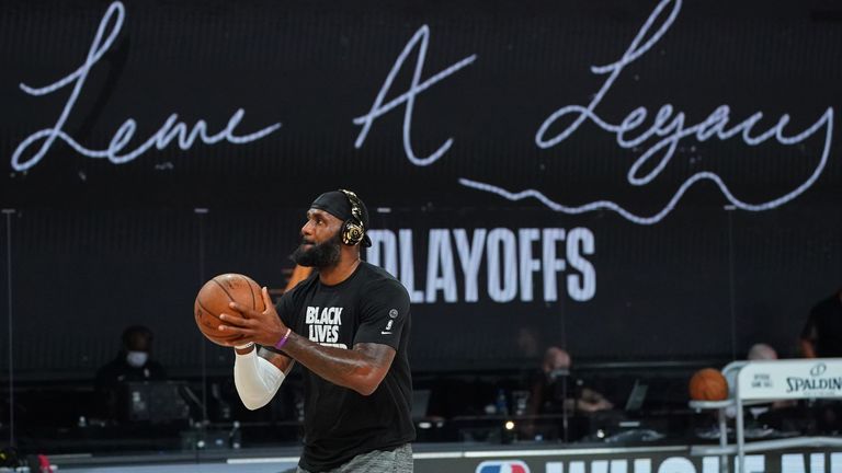 LeBron James warms up in front of the Lakers' Kobe Bryant-inspired 'Leave a Legacy' graphic