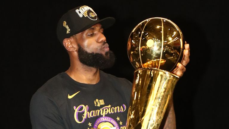LeBron James poses with the Larry O&#39;Brien trophy following the Los Angeles Lakers&#39; NBA championship win