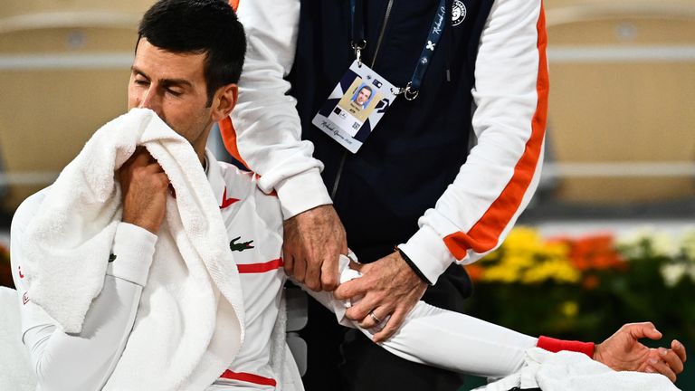 Serbia's Novak Djokovic reacts as he is treated by medical staff eturns the ball during his men's singles quarter-final tennis match against Spain's Pablo Carreno Busta on Day 11 of The Roland Garros 2020 French Open tennis tournament in Paris on October 7, 2020