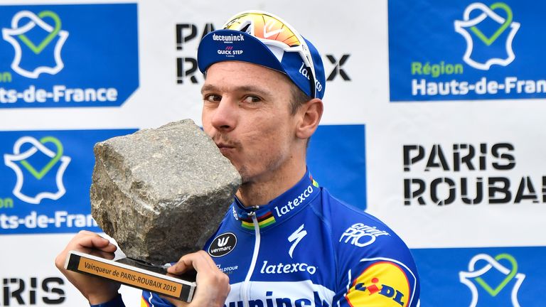 2019 winner Belgium's Philippe Gilbert kisses his trophy on the podium of the 117th edition of the Paris-Roubaix one-day classic cycling race.