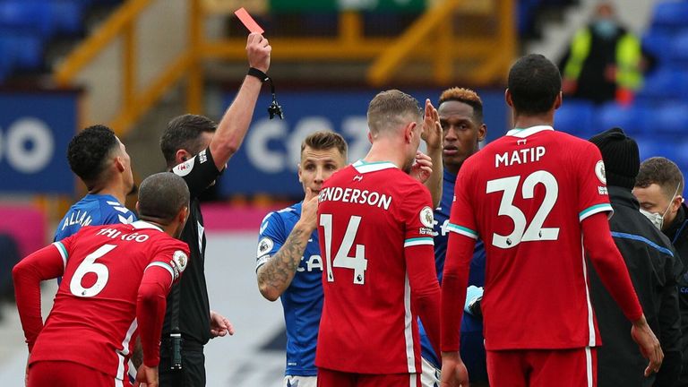 Richarlison (obscured) is shown a red card by referee Michael Oliver