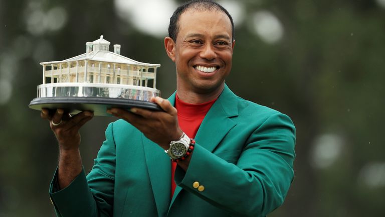 Tiger Woods proudly holds aloft the Masters Trophy, which depicts the Augusta National clubhouse