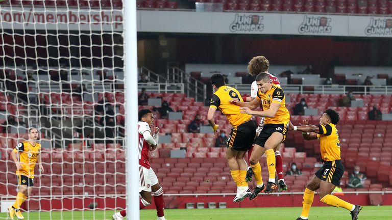 Conor Coady jumps for the ball immediately behind Jimenez and Luiz 