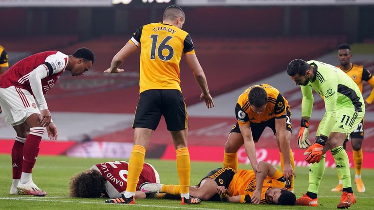 Players react after Arsenal's Brazilian defender David Luiz clashes heads with Wolverhampton Wanderers' Mexican striker Raul Jimenez during the English Premier League football match between Arsenal and Wolverhampton Wanderers at the Emirates Stadium in London on November 29, 2020