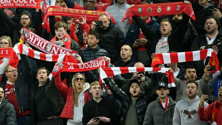 Liverpool fans at Anfield hold their scarves aloft