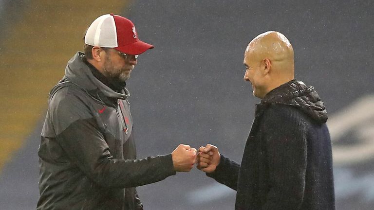 Jurgen Klopp (L) bumps fists with Manchester City&#39;s Spanish manager Pep Guardiola (C) at the end of the game during the English Premier League football match between Manchester City and Liverpool at the Etihad Stadium in Manchester, north west England, on November 8, 2020. - The game ended 1-1