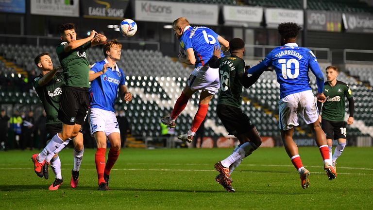PLYMOUTH, ENGLAND - NOVEMBER 16: Kelland Watts of Plymouth Argyle (2L) blocks a header from Jack Whatmough of Portsmouth with his arms resulting in a penalty during the Sky Bet League One match between Plymouth Argyle and Portsmouth at Home Park on November 16, 2020 in Plymouth, England.