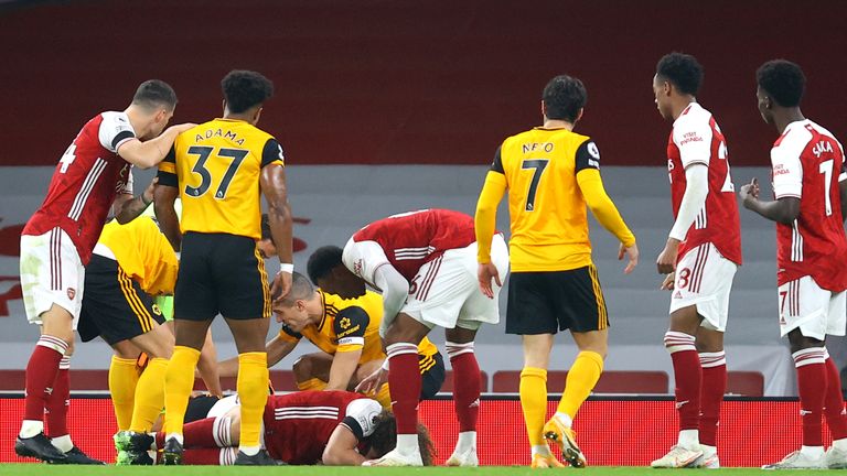 Players check on the condition of Raul Jimemez and David Luiz after a clash of heads