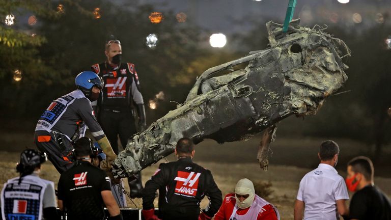 Stewards recover a section of Romain Grosjean's car following a crash during the Bahrain GP