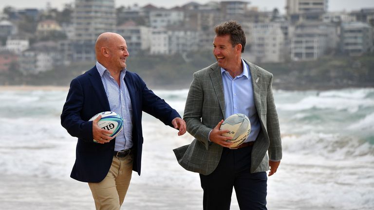 Rugby Australia interim chief executive Rob Clarke (L) and New Zealand Rugby chief executive Mark Robinson walk on Manly Beach after a press conference in Sydney
