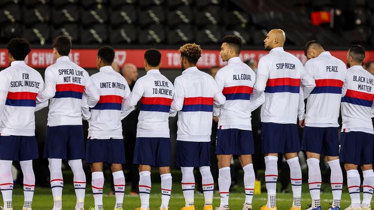 USA players lined up for the national anthems with anti-racism messages on the back of their training tops