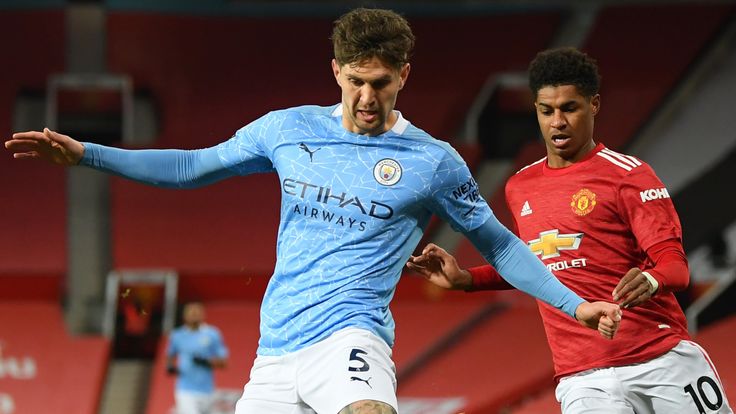 John Stones and Marcus Rashford in action during the Manchester derby