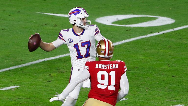 Quarterback Josh Allen of the Buffalo Bills looks to pass under pressure from defensive end Arik Armstead of the San Francisco 49ers