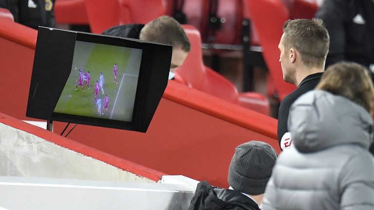 Referee Craig Pawson checks the pitchside monitor before overturning his decision to award a penalty to Wolves