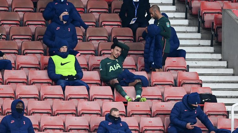 Dele Alli takes a seat in the stand after being substituted