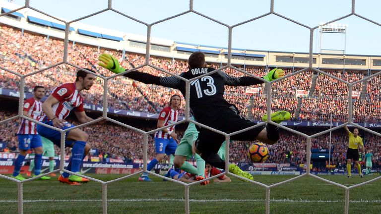 Atletico Madrid's Slovenian goalkeeper Jan Oblak tries to stop a goal by Barcelona's Argentinian forward Lionel Messi during the Spanish league football match Club Atletico de Madrid vs FC Barcelona at the Vicente Calderon stadium in Madrid on February 26, 2017