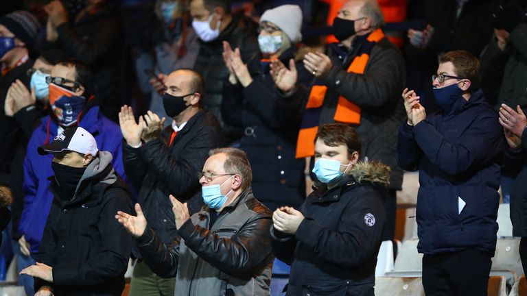 Fans of Luton Town applaud from their socially distanced seating whilst wearing a face mask ahead of the Sky Bet Championship match between Luton Town and Norwich City at Kenilworth Road 