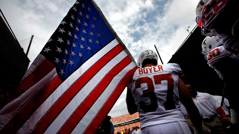 Nate Boyer #37 of the Texas Longhorns carries an American flag as the Texas Longhorns take to the field against the Oklahoma Sooners at Cotton Bowl on October 13, 2012 in Dallas, Texas