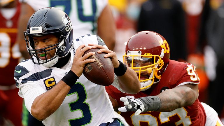 Quarterback Russell Wilson #3 of the Seattle Seahawks eludes the tackle of defensive tackle Jonathan Allen #93 of the Washington Football Team in the second half at FedExField on December 20, 2020 in Landover, Maryland.