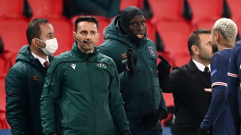 Romanian fourth official Sebastian Coltescu (2nd-L) looks on next to Istanbul Basaksehir's French forward Demba Ba (2nd-R) and Paris Saint-Germain Brazilian forward Neymar (1st-R) during the UEFA Champions League group H football match between Paris Saint-Germain (PSG) and Istanbul Basaksehir FK at the Parc des Princes stadium in Paris, on December 8, 2020. - Paris Saint-Germain's decisive Champions League game with Istanbul Basaksehir was suspended on December 9 in the first half as the players