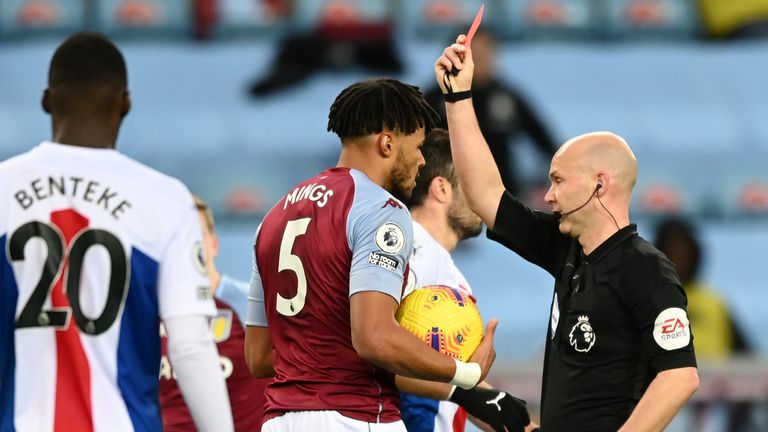 Tyrone Mings is shown a red card late in the first half