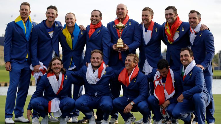 Europe team captain Thomas Bjorn, center, holds the trophy as he celebrates with his team after Europe won the Ryder Cup on the final day of the 42nd Ryder Cup at Le Golf National in Saint-Quentin-en-Yvelines, outside Paris, France, Sunday, Sept. 30, 2018. (AP Photo/Matt Dunham)