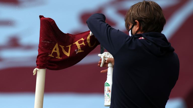 A member of staff disinfects a corner flag before the Premier League match at Villa Park, Birmingham.